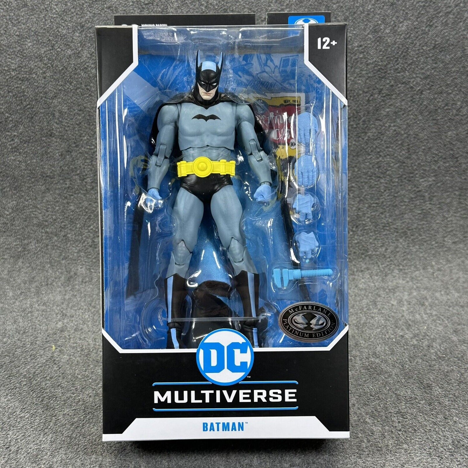 McFarlane DC Multiverse Batman Action Figure, featuring iconic gray and blue suit with yellow utility belt, multiple accessories, and detailed premium packaging.